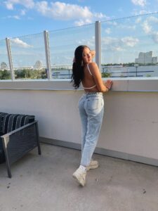 Mila Monet in a white top and jeans